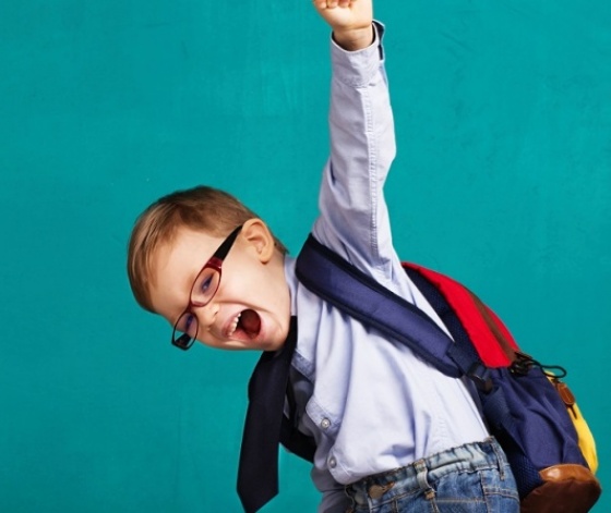 Jeune écolier content de reprendre le chemin de l'école