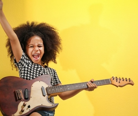 Jeune fille métisse jouant de la guitare électrique