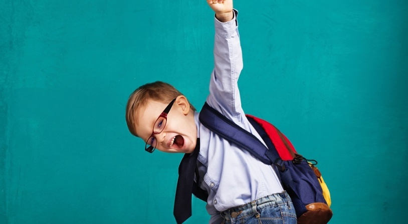 Jeune écolier content de reprendre le chemin de l'école