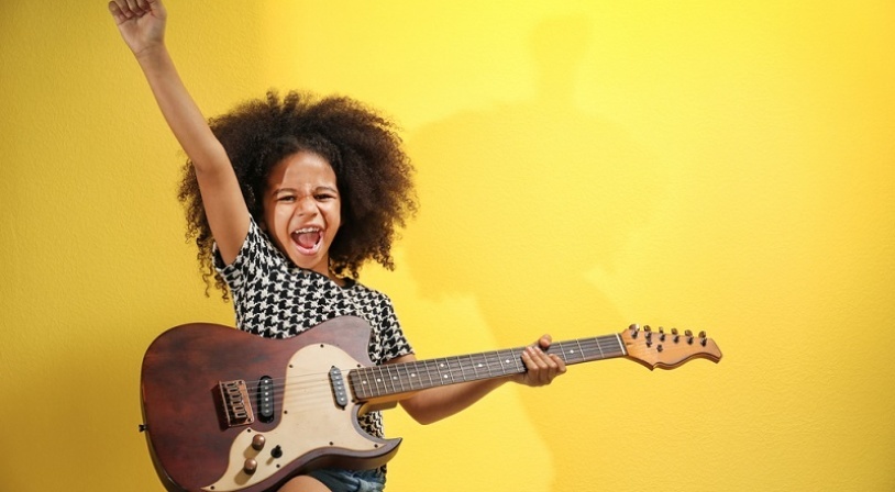 Enfant jouant de la guitare électrique Jeune fille métisse jouant de la guitare électrique