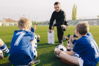 Entraîneur de foot entouré d'enfants