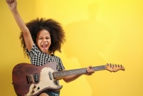 Jeune fille métisse jouant de la guitare électrique